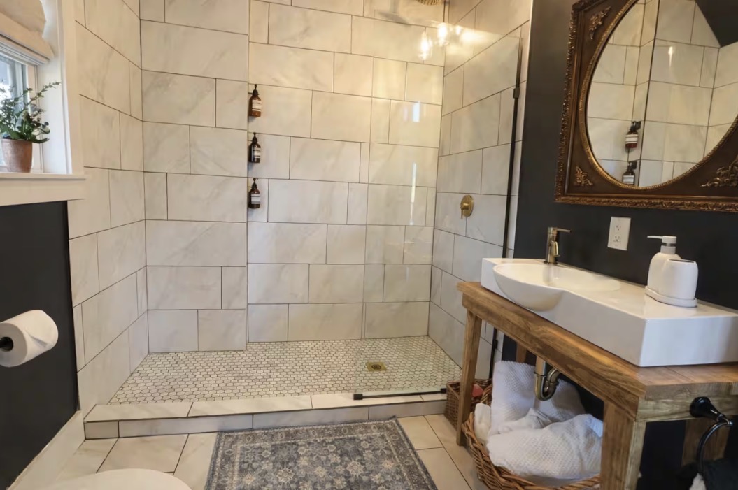 The cabin bathroom with a tiled walk-in shower and antique mirror