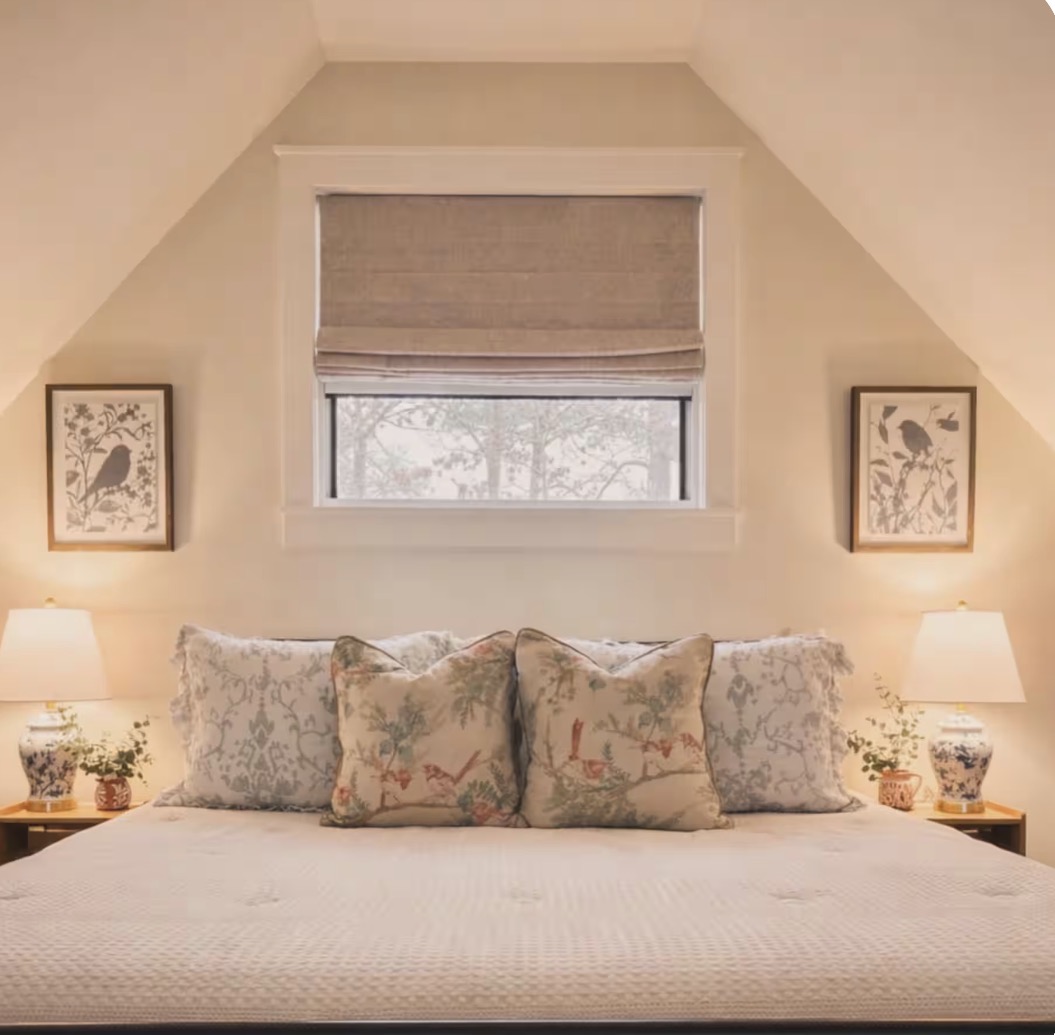 The Rockhill cabin bedroom with floral pillows and warm bedside lamps