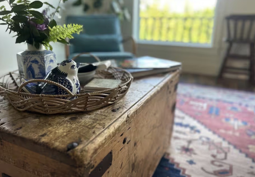 Blue-and-white pottery and flowers on a vintage wooden trunk inside the cabin